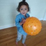 Baby girl learning ball skills
