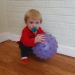 Baby boy learning ball skills